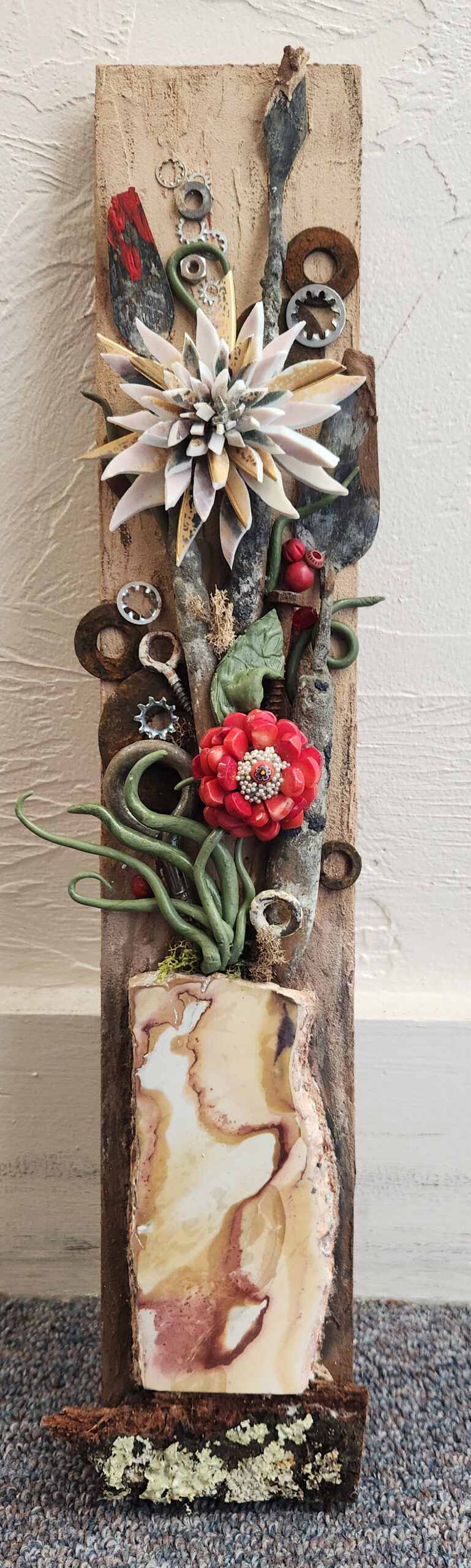 Broken palate knives, crockery, found objects, and putty leaves, create blooms